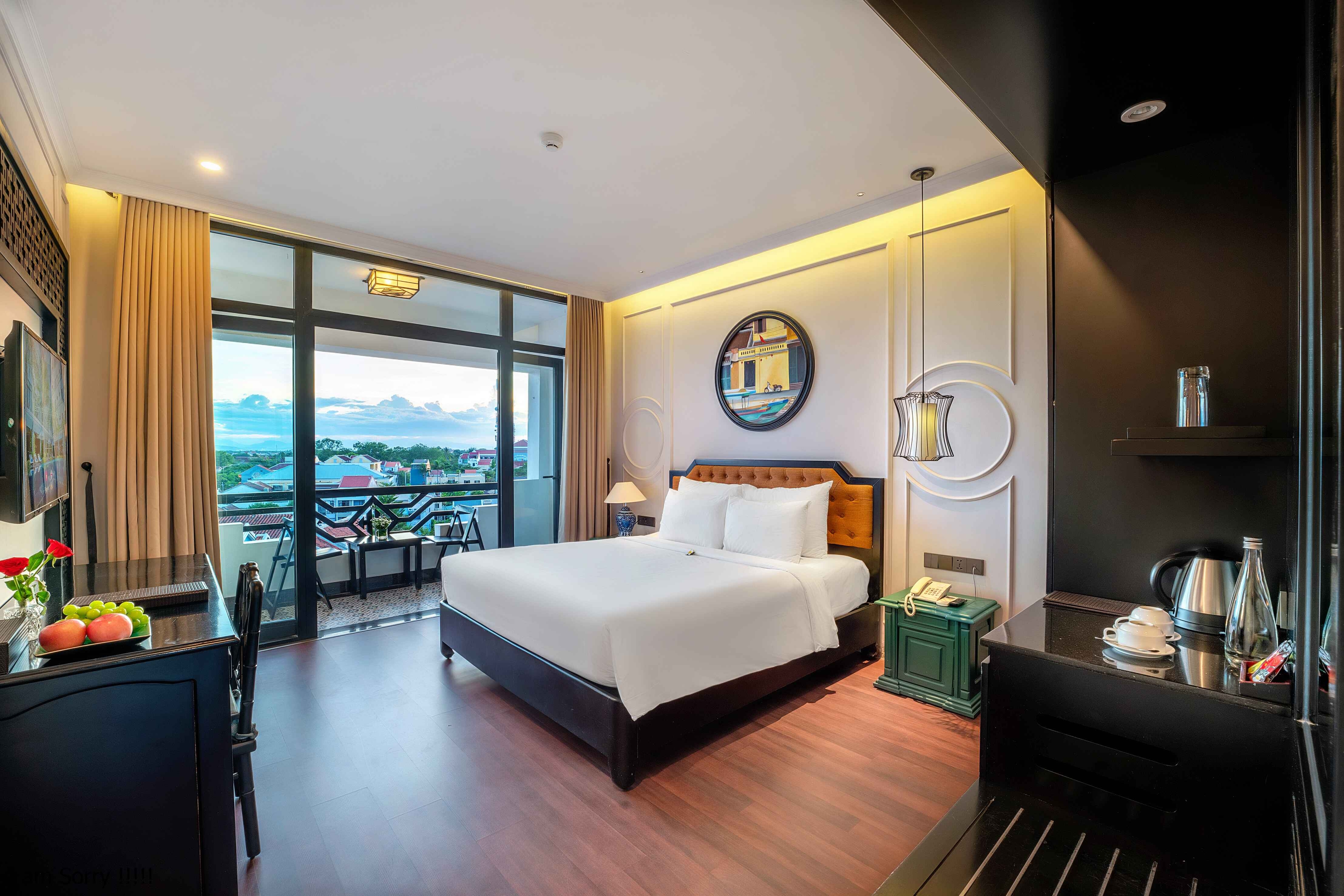 Modern hotel room featuring a large bed, floor-to-ceiling windows with a view, and stylish furnishings